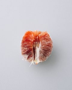 A half of a grapefruit opted for a placement on a white background.