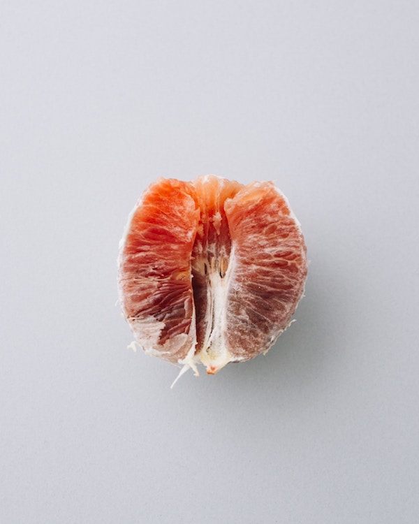 A half of a grapefruit opted for a placement on a white background.