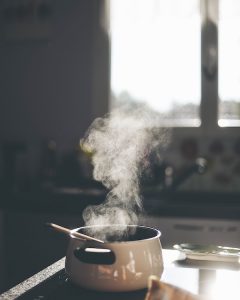 Steam rising from a pot on a stovetop, featuring eco-friendly cookware.