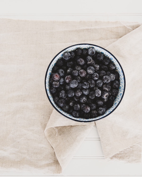 Organic blueberries in a bowl on a linen napkin.