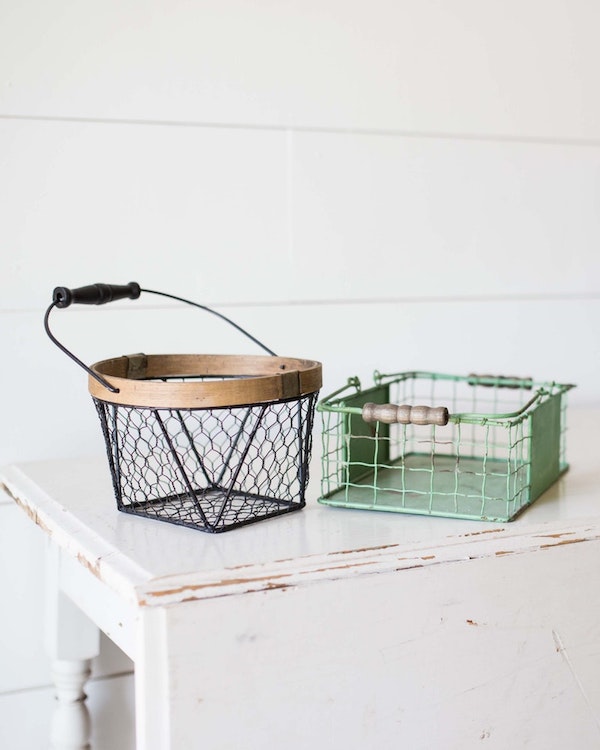 Two eco-friendly wire baskets sitting on top of a white table.