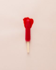 A red popsicle on a white background.