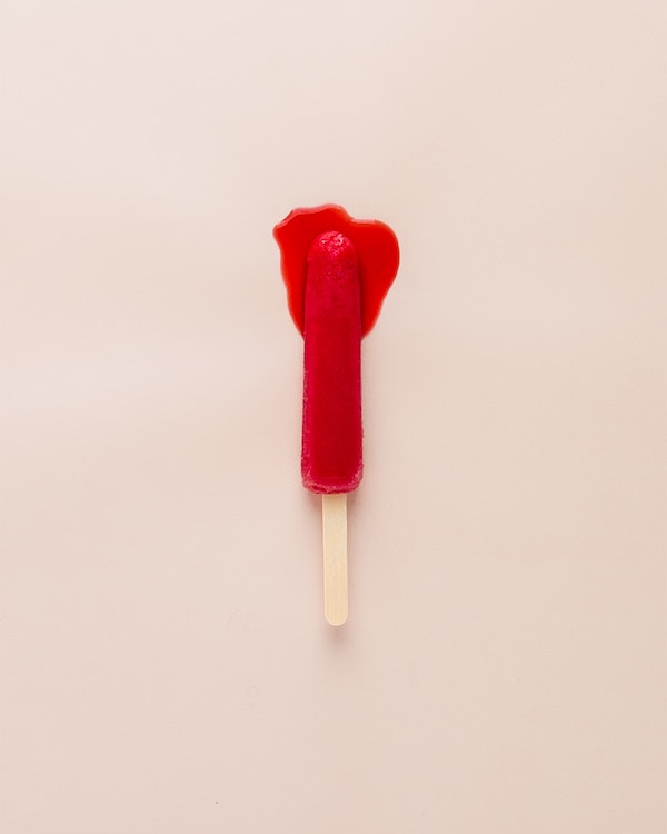A red popsicle on a white background.