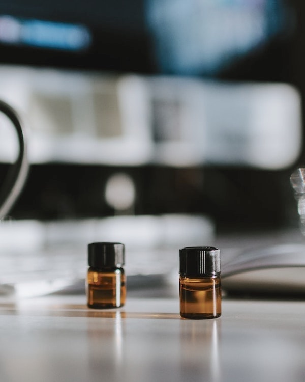 Two small bottles of eco-friendly essential oils on a desk.