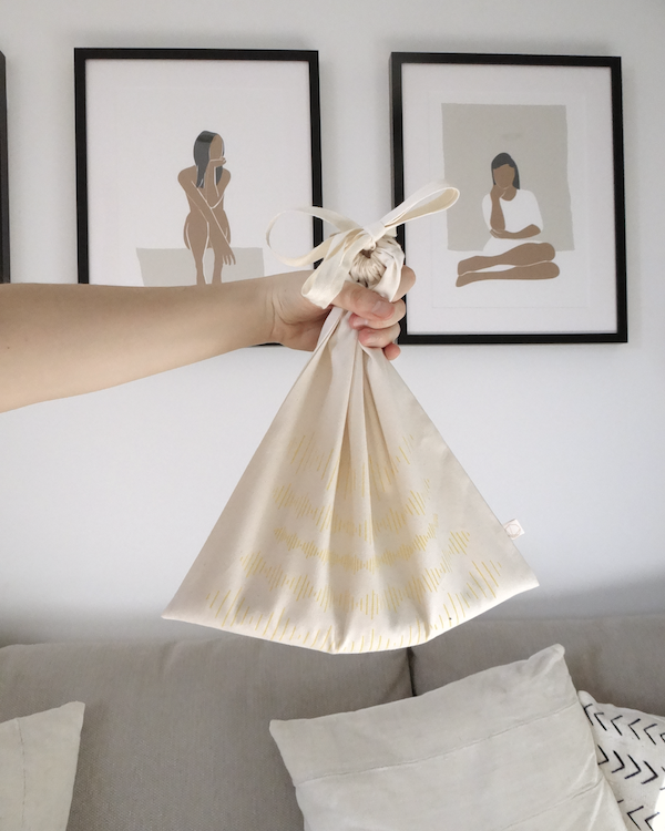 A person holding up a white produce bag with a quote on it.