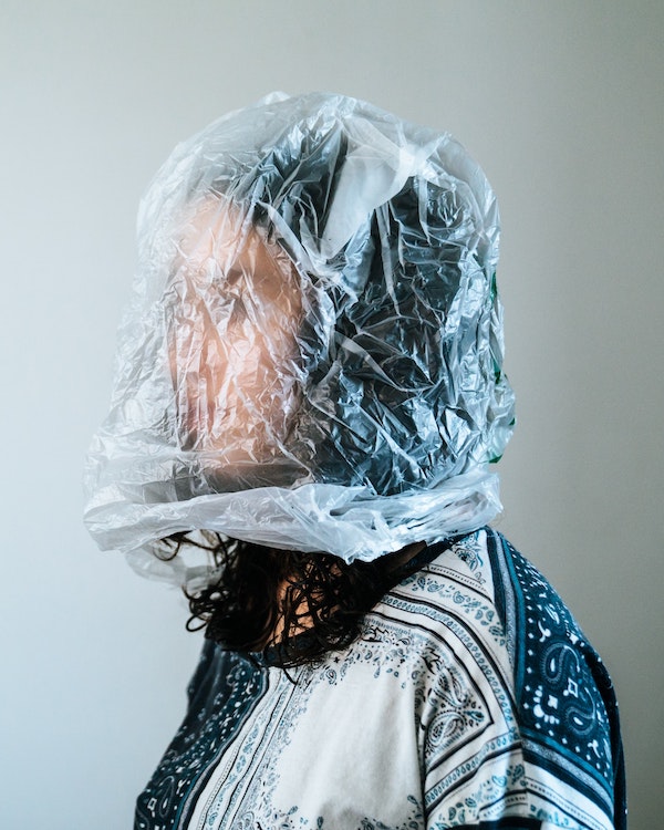 A woman wearing a plastic bag over her head, highlighting the shocking facts about plastic pollution.