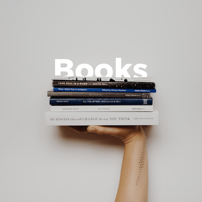 A person holding a stack of books on the homepage landing page.
