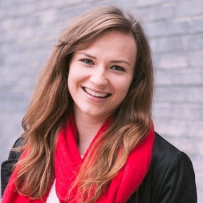 A smiling woman wearing a red scarf.